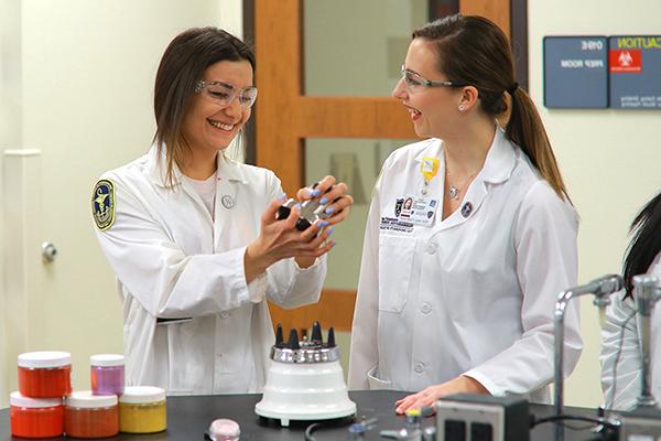 A cosmetic science student working with a professor in a lab