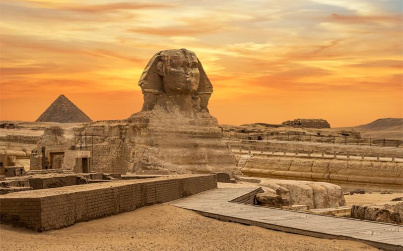 sunset landscape view of famous Ancient Egyptian structures featuring the pyramids