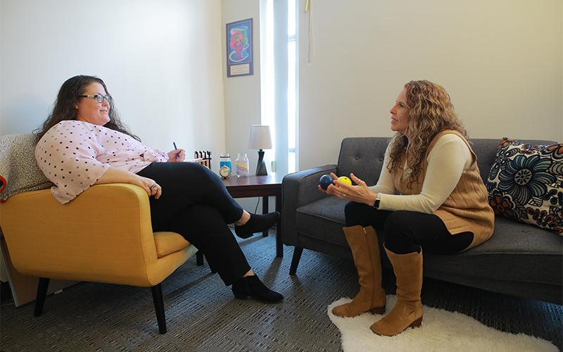 counselor sitting on couch talks to patient