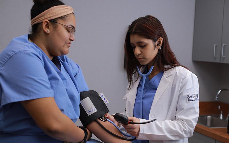doctor obeserves blood pressure measurements of her patient
