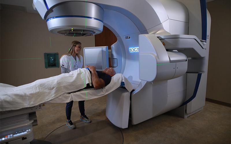 doctor takes measurements of patient laying in down on a medical scanner and imaging machine